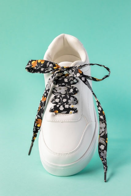 Lacets en tissu noir fleuris or pour pimper ses baskets, fabriqué à Lyon par Pop Lacets.