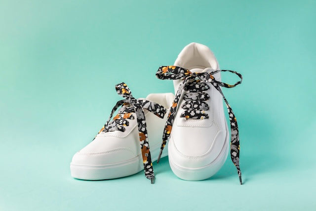 Lacets en tissu noir à fleurs dorées pour une touche d'élégance sur les chaussures.